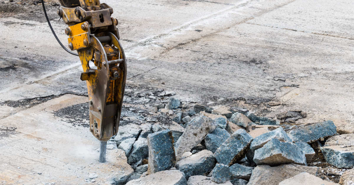 excavator mounted hydraulic jackhammer at breaking concrete area closeup of working demolition